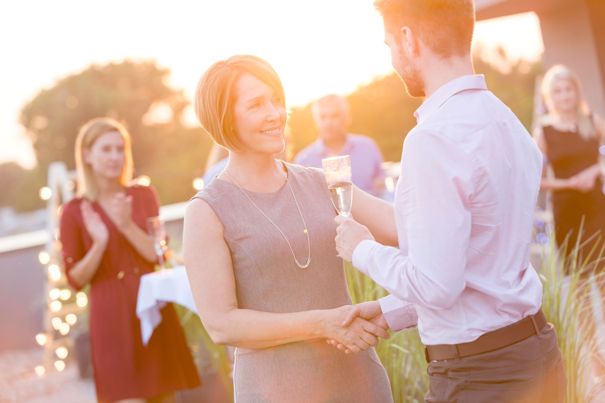 Woman shaking hands with man at event outdoors